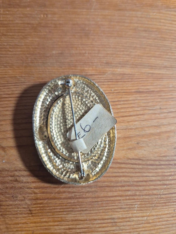 Gold tone and black brooch