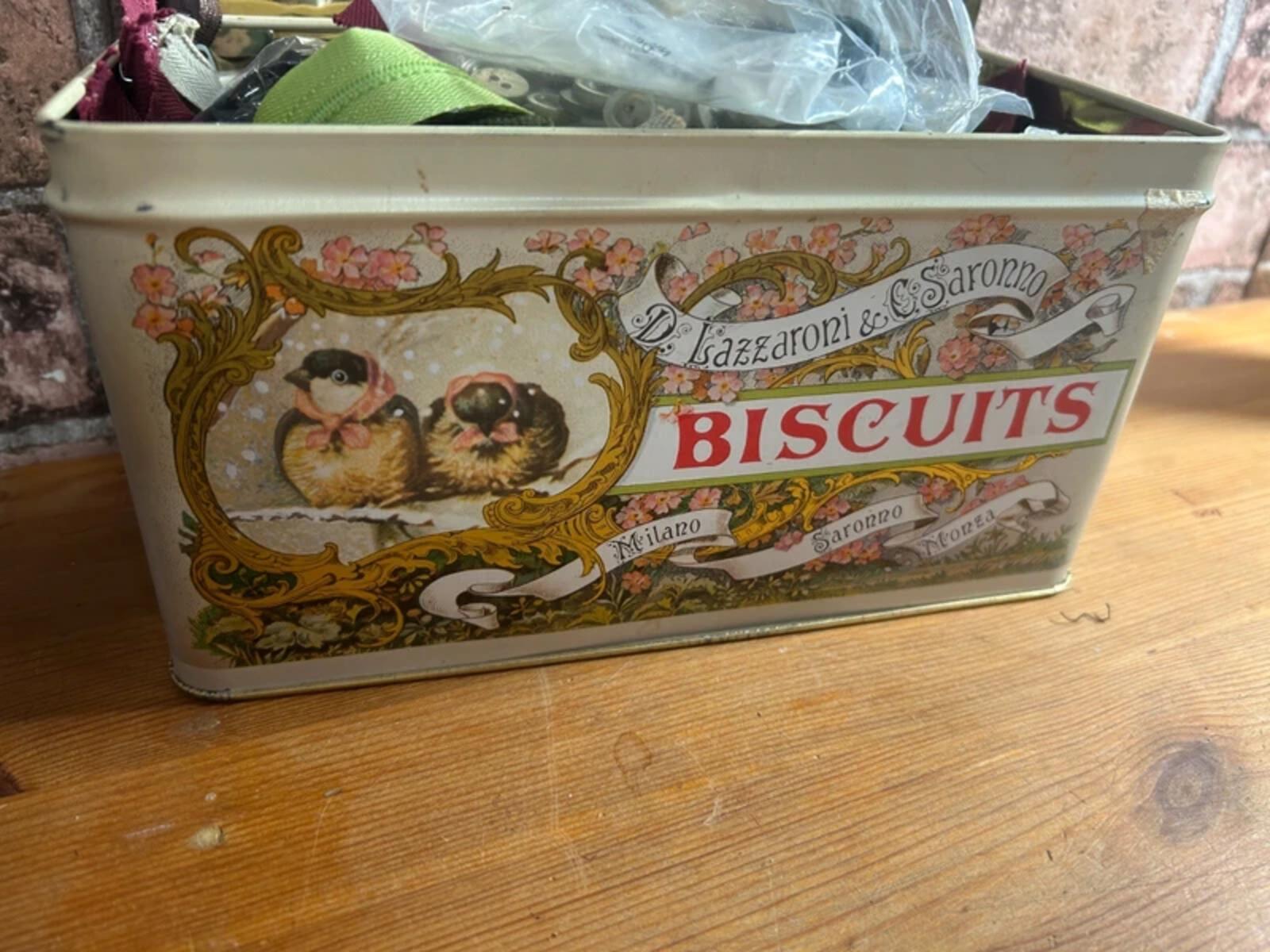 Bundle of zips and buttons in vintage tin